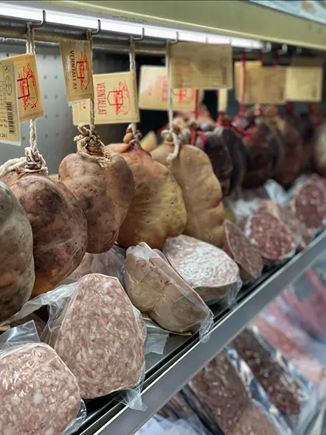 Expositor amb embotits tradicionals de la Cooperativa Verntallat, curats i envasats al buit, preparats per a la venda.