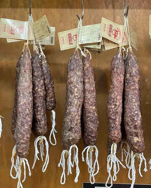 Embotits tradicionals penjats, preparats per al procés de curació natural.