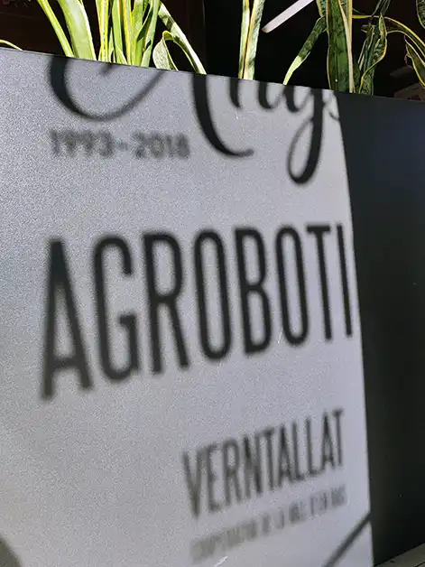 Detall del rètol commemoratiu de l’Agrobotiga Verntallat amb la inscripció dels anys i el nom destacat.